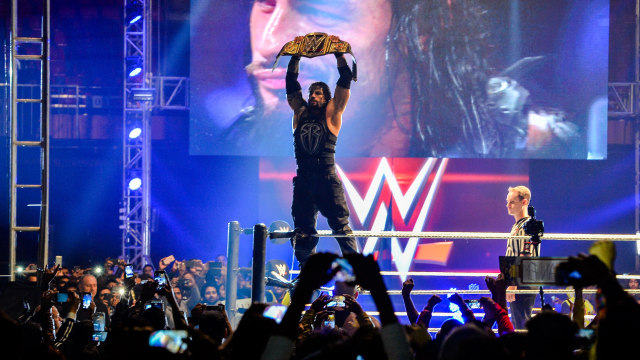 Roman Reigns dengan sabuk WWE Championship-nya. (Foto: Chandan Khanna / AFP)
