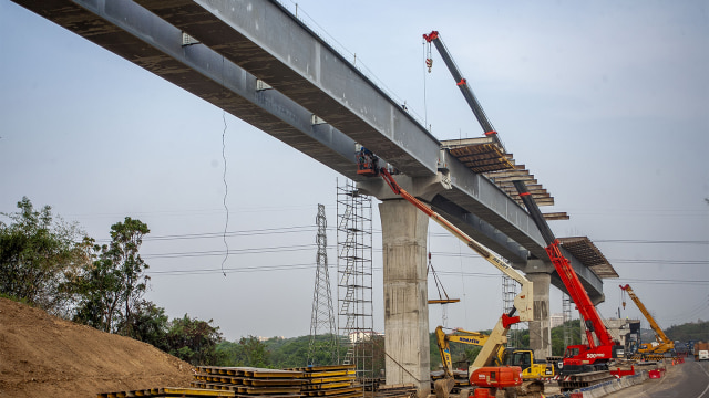 Pekerja mengoperasikan alat berat saat menyelesaikan pembangunan jalan tol layang Jakarta-Cikampek II Elevated di Karawang, Jawa Barat. (Foto: ANTARA FOTO/M Ibnu Chazar)