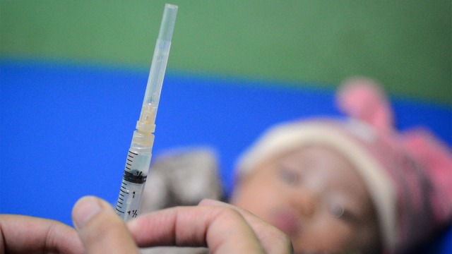 Seorang bidan menyiapkan suntikan yang berisi vaksin DPT saat mengadakan imunisasi. (Foto: ANTARA FOTO/Raisan Al Farisi)