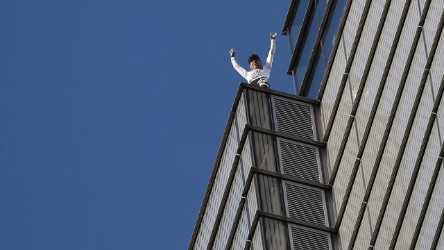 Alain Robert memanjat gedung tertinggi di London, Heron Tower, pada Kamis (25/10). (Foto: Daniel Leal-Olivas/AFP)