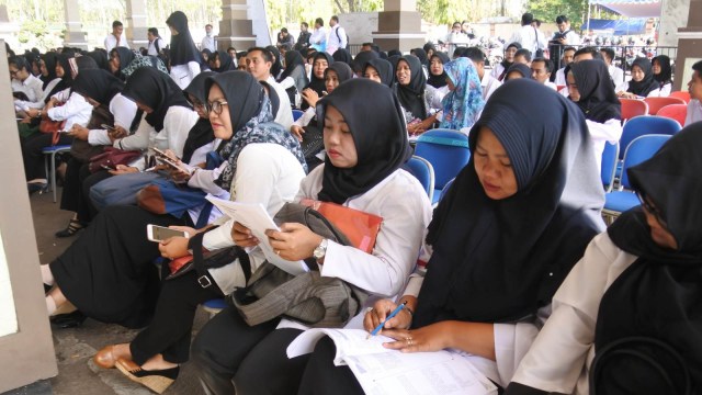 Peserta duduk di ruang tunggu sebelum mengikuti ujian seleksi calon pegawai negeri sipil (CPNS) di Gedung Serbaguna Kaliwates, Jember, Jawa Timur, Jumat (26/10/2018).  Foto: ANTARA FOTO/Seno