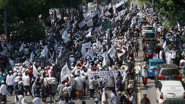 Massa yang tergabung dalam Barisan Nusantara Pembela Tauhid membawa bendera bertuliskan kalimat tauhid di Jalan Medan Merdeka Barat, Jakarta Pusat, Jumat (26/10/2018). (Foto: Jamal Ramadhan/kumparan)