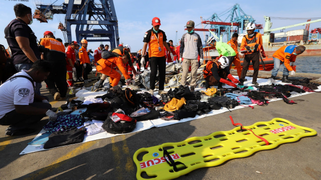 Anggota tim penyelamat membawa barang-barang pribadi dan puing-puing ke pantai di pelabuhan di Tanjung Priok, Senin (29/10/2018). (Foto: AFP PHOTO/Resmi Malau)