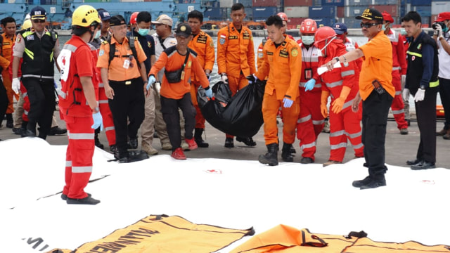 Petugas membawa kantong jenazah yang berisi serpihan kursi pesawat Lion Air JT-610, Selasa (30/10/2018). (Foto: Irfan Adi Saputra/kumparan)