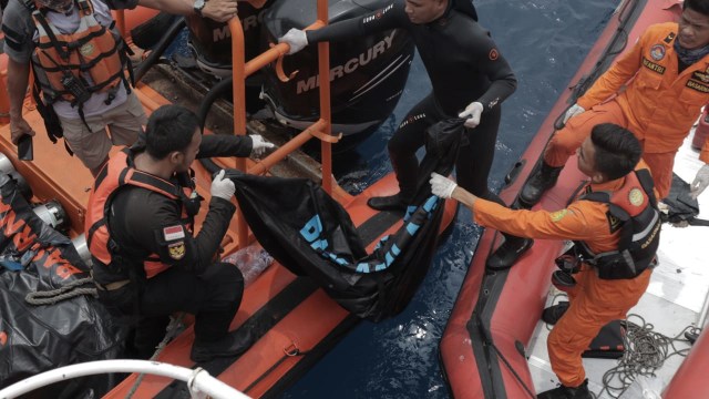 Sejumlah anggota Basarnas membawa puing-puing pecahan pesawat Lion Air JT-610 dan jenazah korban ke dalam kapal induk Basarnas di perairan Tanjung Pakis, Karawang, Selasa (30/10). (Foto: Aditia Noviansyah/kumparan)