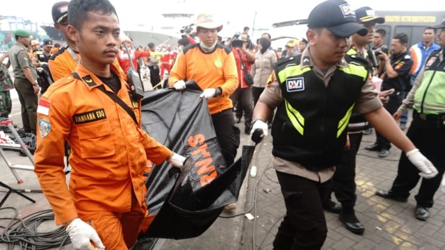 Petugas membawa kantong jenazah korban pesawat Lion Air JT-610 di Dermaga JICT, Selasa (30/10/2018). (Foto: Irfan Adi Saputa/kumparan)