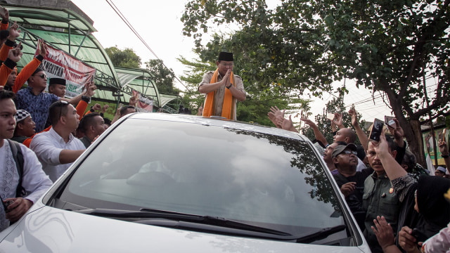 Calon Presiden no urut 02 Prabowo Subianto menyapa warga dari atas kendaraan saat kegiatan kunjungan di Pondok Pesantren Ta'mirul Islam, Solo. (Foto: ANTARA FOTO/Mohammad Ayudha)