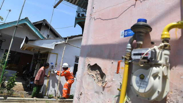 Petugas memberikan penjelasan terkait meteran gas kepada warga di salah satu rumah warga pengguna jaringan gas bumi PGN. Foto: ANTARA FOTO/Zabur Karuru