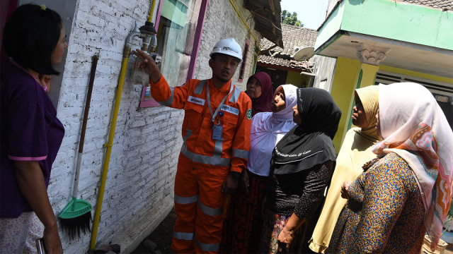 Petugas memberikan penjelasan terkait meteran gas kepada warga di salah satu rumah warga pengguna jaringan gas bumi PGN. Foto: ANTARA FOTO/Zabur Karuru