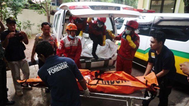 Sejumlah petugas PMI dan tim forensik menurunkan dua kantong jenazah korban Lion Air JT-610 di RS Polri. (Foto: Irfan Adi Saputra/kumparan)