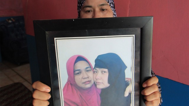 Iti Sartini (52) menunjukkan foto anaknya Tuti Tursilawati yang dihukum mati di Arab Saudi di kediamannya di Desa Cikeusik. (Foto: ANTARA FOTO/Dedhez Anggara)