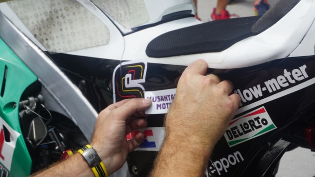 Menempelkan stiker bengkel Indonesia di motor LCR Honda. Foto: Anju Christian/kumparan