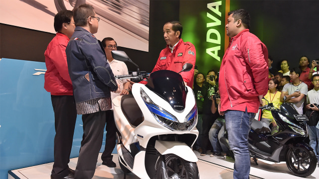 Presiden Joko Widodo (kedua kanan) mengamati motor listrik pada pameran Indonesia Motorcycle Show (IMOS) 2018. (Foto: ANTARA FOTO/Puspa Perwitasari)