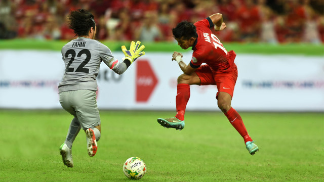Penyerang Timnas Singapura, Khairul Amri (merah), saat berlaga di Piala AFF. (Foto:  Photographer	Roslan Rahman/AFP)