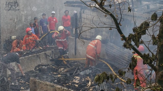 Petugas pemadam kebakaran memadamkan api di komplek Green Garden, Kedoya Utara, Kebon Jeruk, Jakarta Barat, Jumat (9/11/2018). (Foto: Jamal Ramadhan/kumparan)