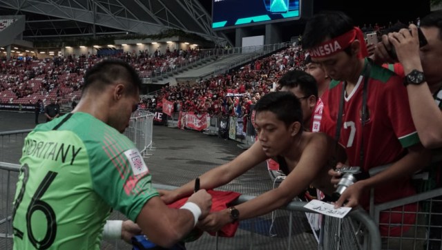 Andritany Adhiyasa menandatangani kaus suporter usai pertandingan Indonesia vs Singapura di babak penyisihan Piala AFF 2018 (Foto: Helmi Afandi/kumparan)