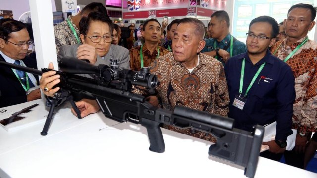 Menteri Pertahanan Ryamizard Ryacudu melihat miniatur senapan dalam acara pameran Indo Defence Expo & Forum di Jiexpo Kemayoran Jakarta, Jumat (9/11/2018). (Foto: Jamal Ramadhan/kumparan)