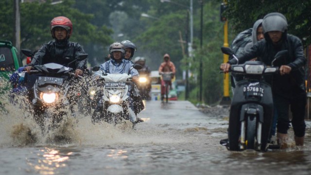 Pengendara melintasi banjir di Dayeuhkolot, Kabupaten Bandung, Minggu (11/11/2018).  (Foto: ANTARA FOTO/Raisan Al Farisi)
