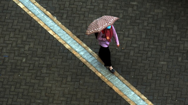Seorang warga berjalan menggunakan payung saat turun hujan. Foto: ANTARA FOTO/Abriawan Abhe