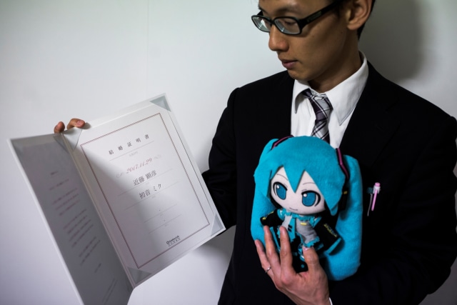 Akihiko Kondo menunjukan sertifikat pernikahannya dengan Hatsune Miku, boneka penyanyi virtual. (Foto: AFP/BEHROUZ MEHRI)