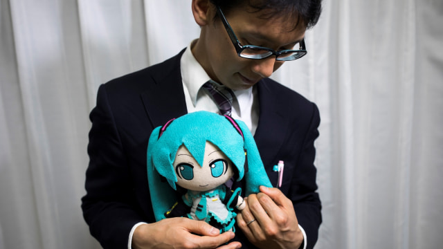 Akihiko Kondo pria di Jepang yang menikah dengan Hatsune Miku, boneka penyanyi virtual menunnjukan cincin pernikahan mereka. (Foto: AFP/BEHROUZ MEHRI)