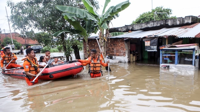 Personel SAR Palembang mengevakuasi warga yang menjadi korban banjir di Sekip Bendung, Palembang, Sumatera Selatan, Selasa (13/11/2018). (Foto: ANTARA FOTO/Nova Wahyudi)