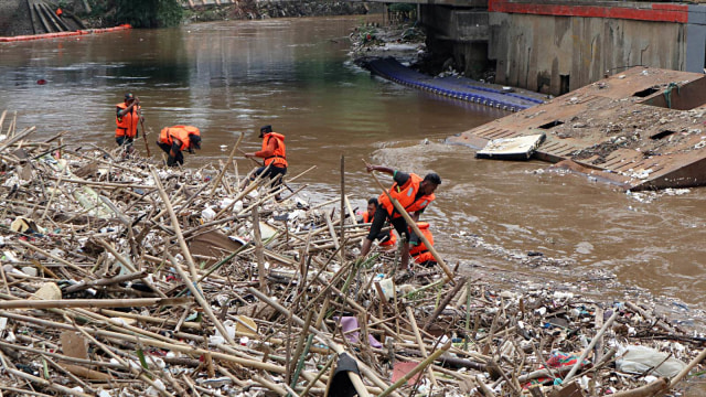 Petugas Dinas Kebersihan DKI Jakarta membersihkan sampah yang menumpuk di pintu air Manggarai, Jakarta, Senin (12/11/2018). (Foto: ANTARA FOTO//BPJSTK-Ahmad Fachri)