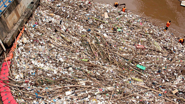 Petugas Dinas Kebersihan DKI Jakarta membersihkan sampah yang menumpuk di pintu air Manggarai, Jakarta, Senin (12/11/2018). (Foto: ANTARA FOTO/Galih Pradipta)