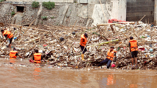 Petugas Dinas Kebersihan DKI Jakarta membersihkan sampah yang menumpuk di pintu air Manggarai, Jakarta, Senin (12/11/2018). (Foto: ANTARA FOTO/Galih Pradipta)