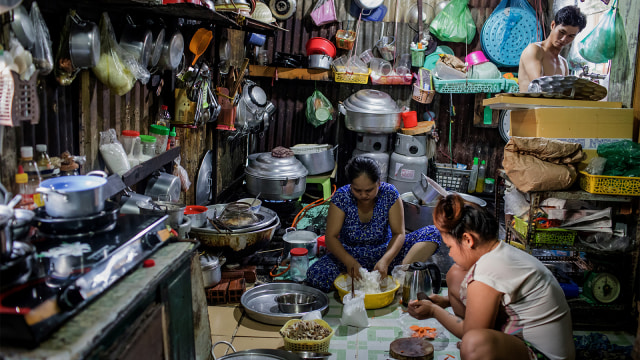 Seorang ibu memasakan di dapur yang sempit di kawasan padat penduduk kanal Xuyen Tam di Kota Ho Chi Minh. (Foto: Kao Nguyen / AFP)