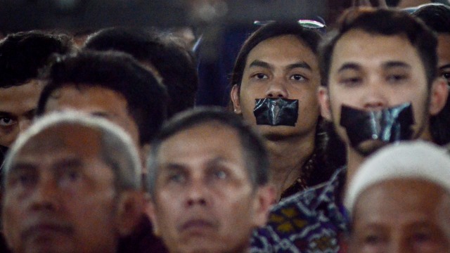 Sejumlah mahasiswa melakukan aksi tutup mulut di Kampus Universitas Islam Bandung (Unisba), Jawa Barat, Sabtu (17/11/2018). Aksi tutup mulut tersebut dilakukan saat orasi ilmiah Wapres Jusuf Kalla dalam Rangka Milad ke-60 Unisba. (Foto: ANTARAFOTO/Raisan Al Farisi)
