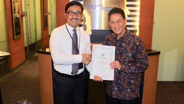 Executive Vice President Kredit Konsumer Bank BRI, Sutadi (kiri), menyerahkan kontrak kerja sama kepada Direktur Utama BFI Finance Francis Lay Sioe Ho. (Foto: Dok. BRI)