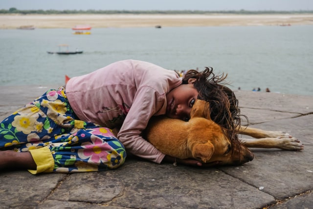 Ilustrasi Anak Kecil di India Memeluk Anjing (Foto: Shutter Stock)