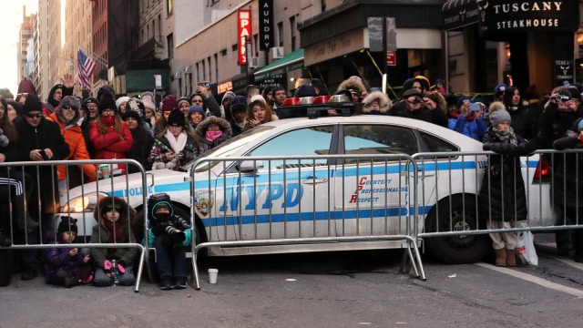 Untuk menghindari terjadinya hal-hal yang tidak diinginkan, pihak keamanan bersiap siaga menjaga jalannya parade di antara barikade penonton.  (Foto:  REUTERS/Brendan McDermid)