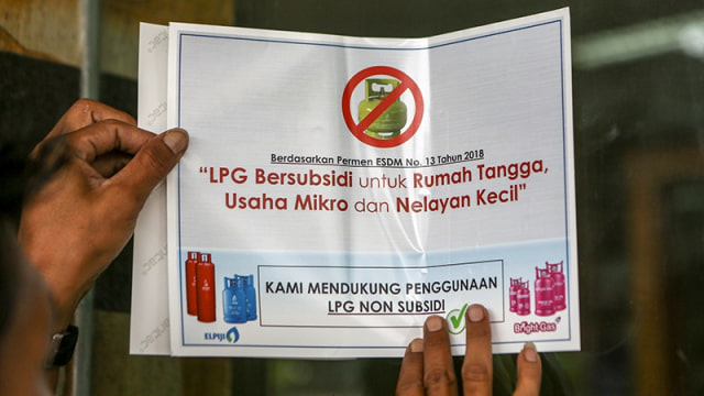 Petugas dari Dinas Perindustrian dan Perdagangan Kota Palembang memasang stiker himbauan pemakaian elpiji 3kg disalah satu rumah makan di Palembang. (Foto: Antara FOTO/Nova Wahyudi)