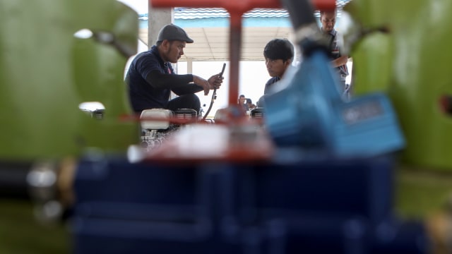 Sejumlah pekerja merakit paket konverter kit mesin perahu berbahan bakar gas di pelabuhan sei lais Palembang, Sumatera Selatan. (Foto: Antara FOTO/Nova Wahyudi)