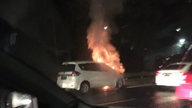 Mobil terbakar di tol JORR arah Taman Mini, Senin (26/11). (Foto: twitter/rivai_jt)