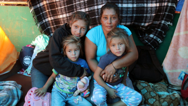 Maria Lila Meza Castro (kanan belakang) seorang migran wanita berusia 39 tahun dari Honduras, bersama anaknya. (Foto: REUTERS / Lucy Nicholson)
