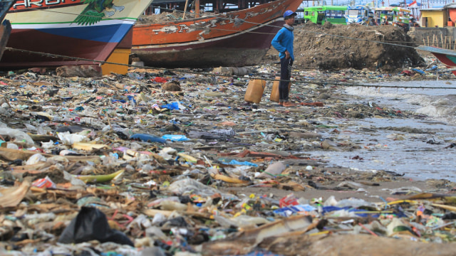 Nelayan menyandarkan perahunya di bibir pantai yang dipenuhi sampah plastik di Desa Dadap, Indramayu, Jawa Barat. (Foto: ANTARA FOTO/Dedhez Anggara)