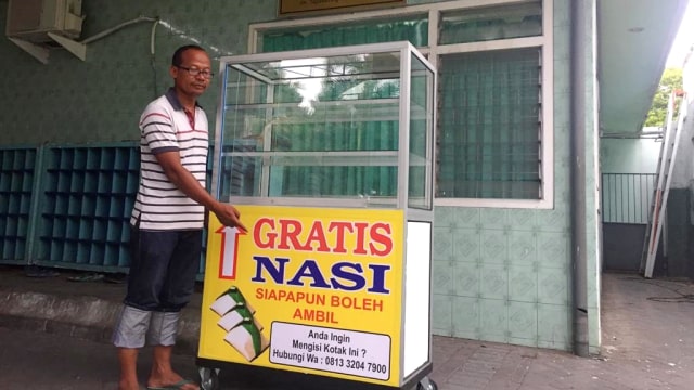Masyarakat Surabaya menunjukan etalase kaca yang berisi makanan gratis. (Foto: Phaksy Sukowati/kumparan)