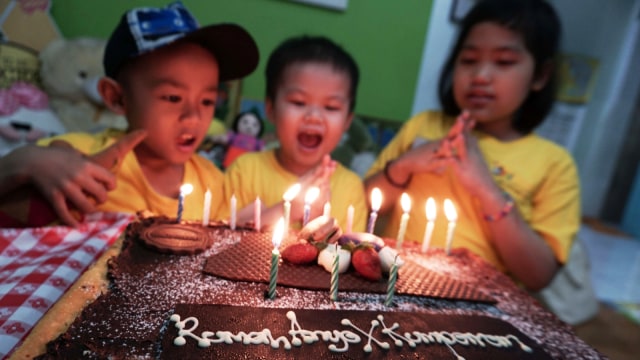 Anak penyandang kanker di Yayasan Anyo Indonesia meniup lilin di kue. (Foto: Jamal Ramadhan/kumparan)