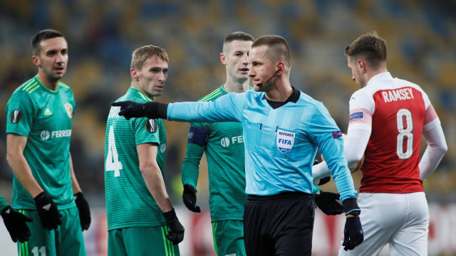 Wasit Bartosz Frankowski asal Polandia menghadiahi tendangan penalti untuk Arsenal. Penalti itu berhasil dikonversi menjadi gol oleh Aaron Ramsey. (Foto: Reuters/Valentyn Ogirenko)