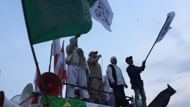 Massa reuni 212 kibarkan bendera berlafal tauhid di area Bundaran Patung Kuda. (Foto: Fachrul Irwinsyah/kumparan)