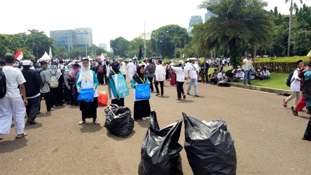 Relawan Reuni 212  membersihkan lokasi sekitaran Monas, Jakarta, Minggu (2/12/2018). (Foto: Rian/kumparan)