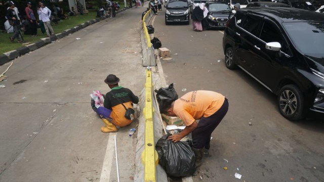 UPK Badan Air DKI Jakarta membersihkan sampah sisa aksi Reuni 212 di Jalan Medan Merdeka Utara, Jakarta Pusat, Minggu (2/12/2018). (Foto: Irfan Adi Saputra/kumparan)