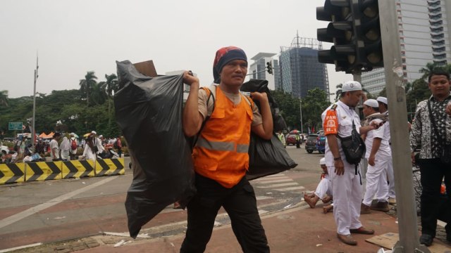 UPK Badan Air DKI Jakarta membersihkan sampah sisa aksi Reuni 212 di Jalan Medan Merdeka Utara, Jakarta Pusat, Minggu (2/12/2018). (Foto: Irfan Adi Saputra/kumparan)