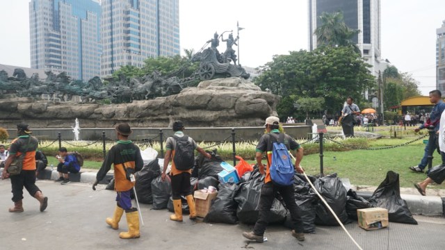 UPK Badan Air DKI Jakarta membersihkan sampah sisa aksi Reuni 212 di Jalan Medan Merdeka Utara, Jakarta Pusat, Minggu (2/12/2018). (Foto: Irfan Adi Saputra/kumparan)