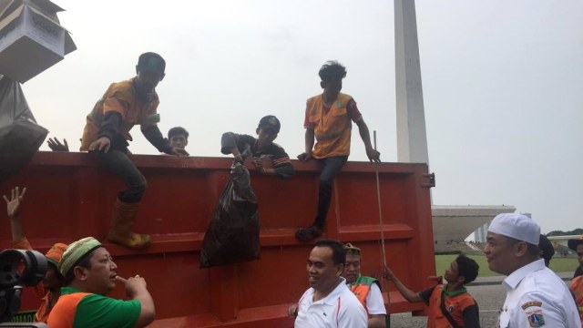 Pasukan oranye membersihkan sisa-sisa sampah usai acara Reuni 212 di Monas, Jakarta Pusat, Minggu (2/12/2018). (Foto: Moh Fajri/kumparan)