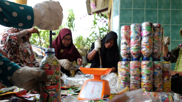 Warga memasukan sampah plastik ke botol minuman bekas dengan menggunakan metode "ecobrick", di Medan. (Foto: ANTARA FOTO/Irsan Mulyadi)