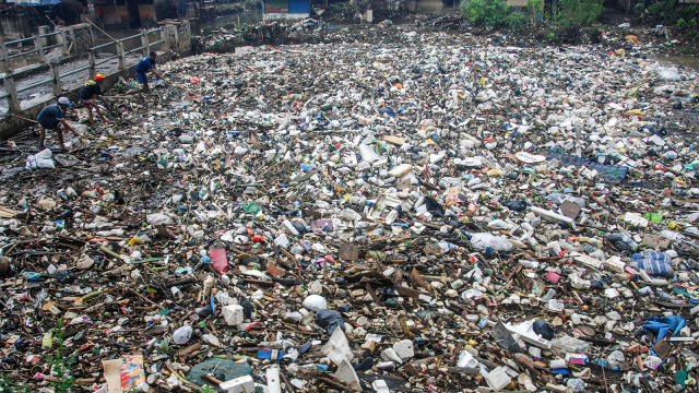 Warga mencari limbah yang dapat didaur ulang di sungai Citarum. (Foto: Timur Matahari / AFP)